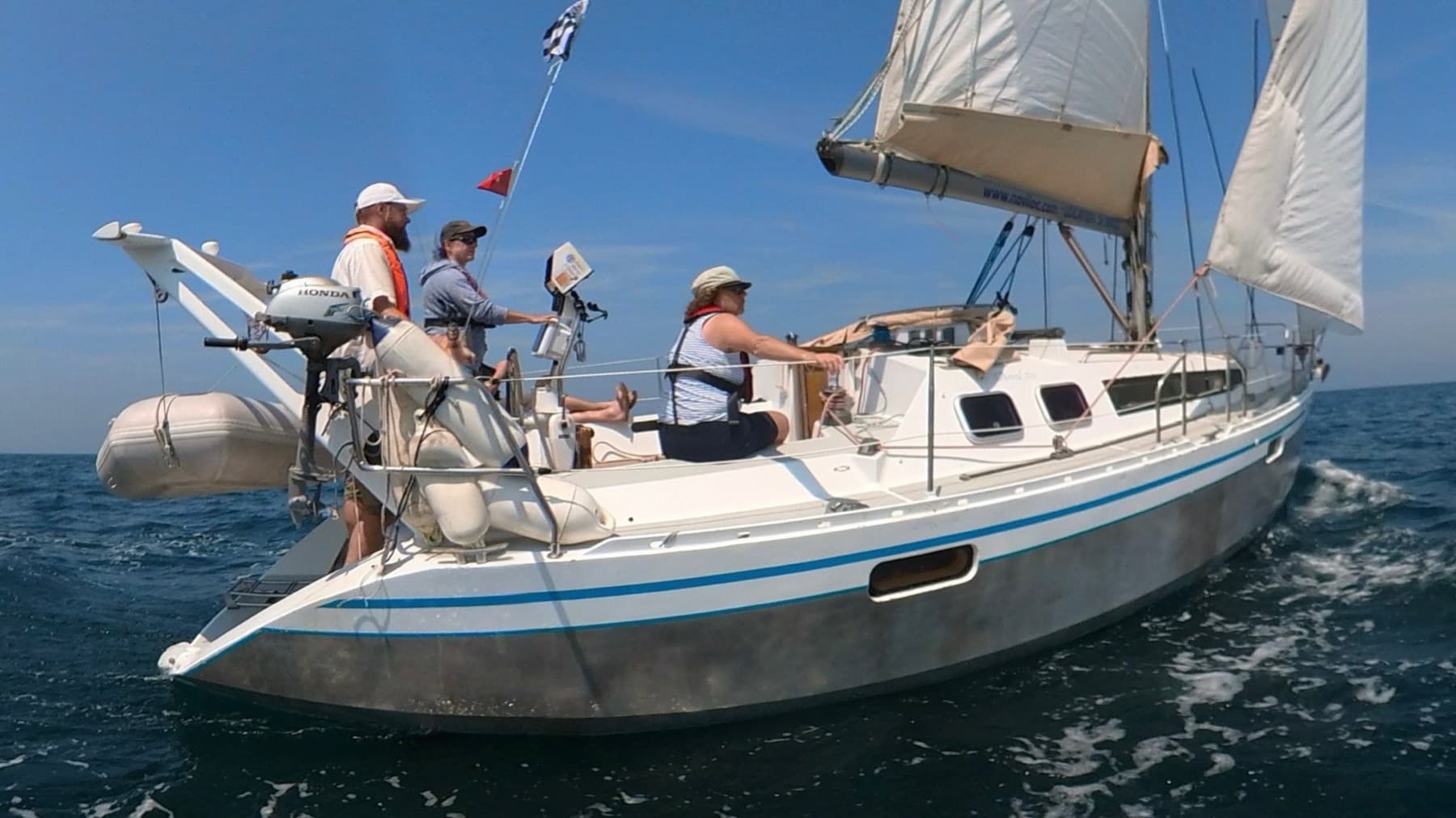 Crew unter Segeln auf einer Yacht bei blauem Himmel — Praxistörn mit Skipper Tommy Bieri.