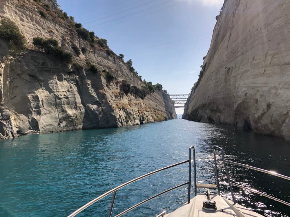 Durchfahrt durch den Kanal von Korinth: steile Felswände, Blick über den Bug der Yacht