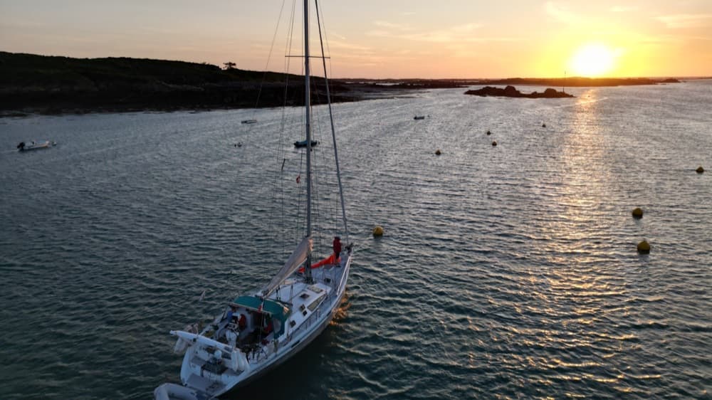 Segelyacht an einer Boje im Abendlicht, von oben über dem Bojenfeld fotografiert